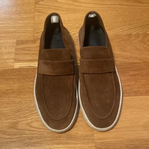 Officine Creative mockaloafer i ljusbrun – handgjord i Italien - Säljer en oanvänd ljusbrun mockaloafer från italienska Officine Creative, handgjord i Montegranaro. Ovandel i mjuk cognac mocka, med klassisk dragflärp på hälen. Sneakersula i naturlatex från Lactae Hevea® (Frankrike) ger fantastisk komfort och grepp. Stilren och flexibel – lika snygg till vardag som formellt. Smal passform, normal i storlek. Dustbag medföljer.  Nypris: 5000 Mitt pris: 2000