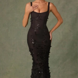 Svart paljettklänning från Oh Polly - Elegant svart långklänning från Oh Polly med glittrande paljettdetaljer och smala axelband. Klänningen har en figurnära passform och är perfekt för festliga tillfällen.                                    Ny, oanvänd klänning från Oh polly nya kollektion. Storlek UK 14 (ca EU 42). Fin passform.   Länk: https://www.ohpolly.com/products/vasanta-embellished-fishtail-corset-gown-black  Nypris inkl frakt: 2100kr