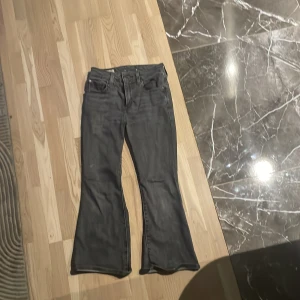 Grå bootcut jeans från Levi's - Snygga grå bootcut jeans från Levi's Premium. Klassisk design med fem fickor och en bekväm passform. Perfekta för en stilren look.