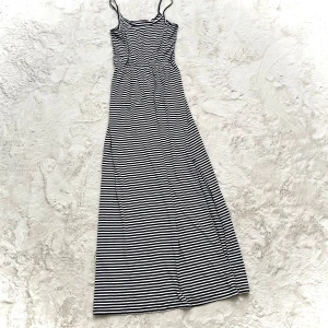 Randig långklänning med smala axelband - Snygg långklänning med svartvita ränder och smala axelband. Perfekt för en avslappnad sommarlook. Klänningen har en enkel och stilren design som passar till många tillfällen.