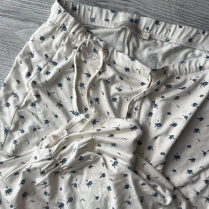 Virala lager 157 pyjamas set - Mysig vit pyjamas med små blå blommor. Setet inkluderar byxor med elastisk midja och en matchande topp med smala axelband. Storlek xs enbart prövade
