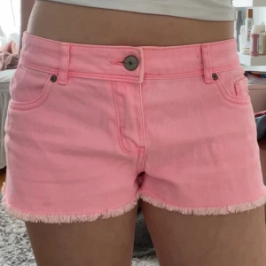 Rosa lågmidjade  jeansshorts - Säljer ett par snygga rosa jeansshorts. De har snygga detaljer på bakfickorna och en väldigt fin färg. Perfekta för sommaren!!💞💞midjemått: 38x2