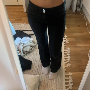 Svarta jeans med knappar - Snygga svarta jeans med låg midja, två knappar där fram. Fickorna har en snygg design där bak. Sitter super bra men är tyvärr för korta och därför säljer jag dom. Inga defekter. Jeansen är i storlek 146/152 från gina young.