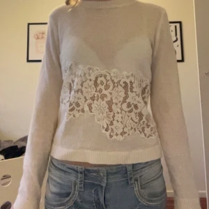 Beige stickad tröja från Zara - Säljer en elegant beige stickad tröja från Zara med vackra spetsdetaljer framtill och baktill. Tröjan har långa ärmar och en mjuk, bekväm passform. Perfekt för en stilren look. Använd endast 2ggr och priset kan diskuteras!