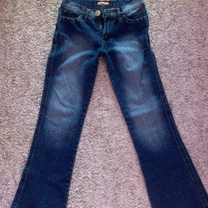 Mörkblå jeans från Onado - Snygga bootcut jeans som säljs då dem är för små för mig. De är små i storleken har snygga detaljer och är lågmidjade. Måtten är 75cm innerbenslängd, 95cm ytterbendlängd och 34/35 cm midjemått tvärs över jeansen.