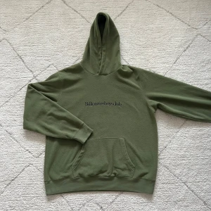 Grön hoodie från Billionaire Boys Club - Säljer en grön hoodie från Billionaire Boys Club med deras logga tryckt på framsidan. Tröjan har en klassisk känguruficka och en liten astronautdetalj på baksidan. Perfekt för en avslappnad stil.