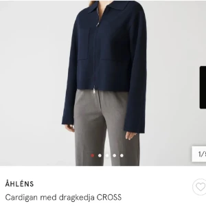 Mörkblå cardigan med dragkedja från Åhléns - Snygg mörkblå cardigan från Åhléns med dragkedja framtill. Jackan har en stilren design med långa ärmar och en krage. Perfekt för en chic och avslappnad look. Slutsåld på hemsidan!