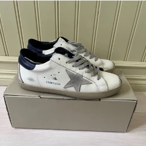 Vit sneaker med stjärndetalj från Golden Goose - Söker byten!   vita sneakers från Golden Goose.använda två gånger så typ helt nya kan säljas till rätt pris.tar emot skor i storlek 43/44.       Har ej kvitto därav priset 