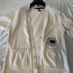 Beige kofta från Tommy Hilfiger - Säljer en stilren beige kofta från Tommy Hilfiger i mjuk och skön bomull. Endast använd ett fåtal gånger och i toppskick! Klassisk design