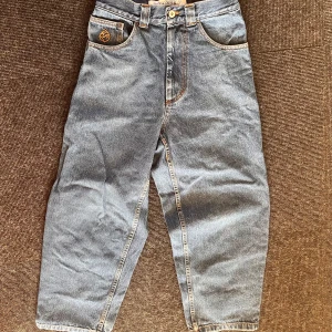 Blå jeans från Big Boy - Säljer ett par Big Boys. De har en loose passform och är dekorerade med en orange broderad logga. De är i väldigt bra skick! Skriv till mig för fler frågor!✅