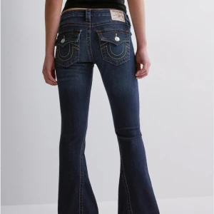 Mörkblå bootcut jeans från True Religion - Säljer ett par mörkblå bootcut jeans från True Religion. De har snygga detaljer med knappar och broderade bakfickor. Köpta här på Plick men som nya.💗