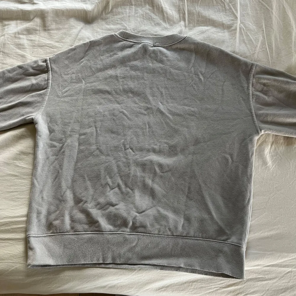 Säljer en stilren grå sweatshirt från Amisu med texten 'PEACEFUL HEART' på bröstet. Tröjan har långa ärmar och en rund halsringning. Perfekt för en avslappnad look.. Neuletakit & Villapaidat.