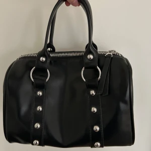 Svart handväska med nitar från Weekday - Handväska från weekday som knappt är använd