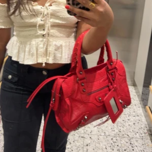 Snygg röd väska - Säljer denna trendiga väska som är i ett gott skick och i en medel stor storlek💕 den har en ficka med dragkedja på insidan och två andra små fickor utan dragkedj på insidan. Kommer med axelband också