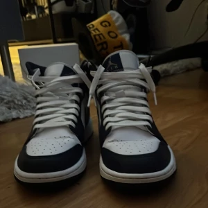 Air Jordan 1 Mid - Snygga svartvita Nike Air Jordans 1 i storlek 43 med en snygg design. Skorna är väldigt varsamt använda ca 10 ggr totalt, finns däremot ingen skolåda kvar men kan säkert lösa kvitto om det skulle önskas.