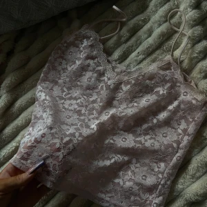 Rosa spetslinne - Säljer ett sött rosa spetslinne med blommigt mönster. Linnet har smala axelband och är perfekt för en romantisk look. Passar bra till både jeans och kjol. 💕 passar xs och lite större eftersom att tyget är lite stretchigt!