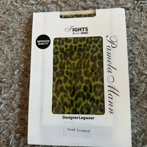 Leopardmönstrade tights från Pamela Mann - Säljer ett par leopardmönstrade tights från Pamela Mann. Tightsen har ett djurmönster i grönt och svart och är märkta som designer legwear. Perfekta för dig som vill sticka ut med din stil. Helt nya. Onesize.