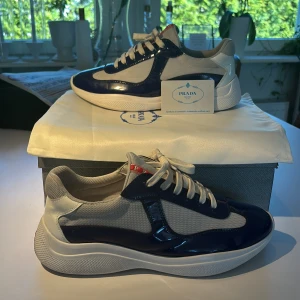 Prada American Cups skor - Hej! Säljer ett par mörkblå Prada American cups skor i riktigt bra skick! Låda, dustbag och ett kort följer med. Har knappt använt dem så både innersulorna och undersidorna är i riktigt bra skick! Hör av dig för mer frågor! Mvh JacobsCloset 
