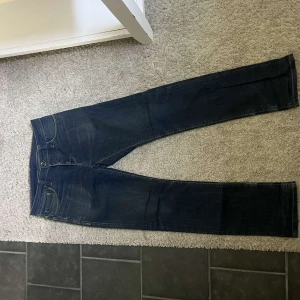 Mörkblå raka jeans - Säljer ett par klassiska mörkblå jeans med raka ben och normal passform. Jeansen har fem fickor, dragkedja och knapp i midjan. Perfekta till vardags och enkla att matcha med olika outfits.