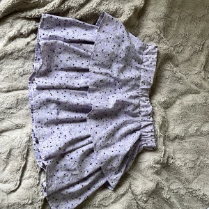 Ljuslila blommig kjol - Supersöt ljuslila kjol med små blommor från name it. Kjolen har volanger och resår i midjan för en bekväm passform. Perfekt för dig som gillar en feminin och lekfull stil. Knappt använd och inga tecken på användning