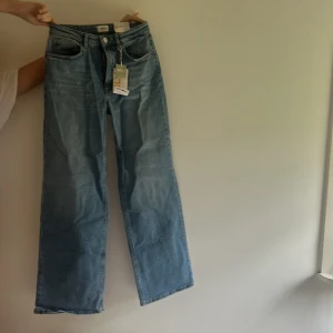 Blå wide leg jeans från ONLY - Säljer ett par blåa wide leg jeans från ONLY, modell Juicy Wide High Waist. Jeansen har hög midja, raka vida ben och klassisk femficksdesign. Perfekta för dig som gillar en avslappnad och trendig look.