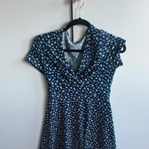 Marinblå, vitblommig klänning  - Jag säljer en oanvänd marinblå blommig klänning från Shein i storlek S 