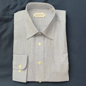 Rutig skjorta från Ralph Boston - Klassisk långärmad skjorta från Ralph Boston i vitt med blått rutmönster. Skjortan har knappar framtill och på ärmsluten, samt en stilren krage. Perfekt för dig som gillar en tidlös och stilren look.ouppackat. 