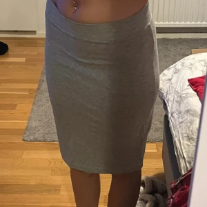Grå kjol - Säljer en enkel och stilren grå kjol från 157 i mjuk bomull. Kjolen är midilång, stretchig och har en tight passform som sitter snyggt på kroppen. Perfekt att matcha med en crop top eller en oversized hoodie. Säljer då den inte kommer till användning längre 💗