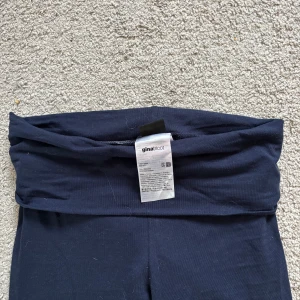 Mörkblå utsvängda leggings från Gina Tricot - Mörkblå leggings från Gina Tricot med låg midja och utsvängda ben. Mjukt och stretchigt material som sitter bekvämt. Perfekta för en avslappnad och trendig stil.