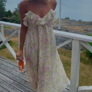 Blommig långklänning med volang från H&M - Säljer den super populära, fina och slutsålda klänningen från h&m! Den är i storlek L men passar mig som brukar ha S/M beroende på hur man vill att den ska sitta. Perfekt för midsommar eller skolavslutningen 🥹