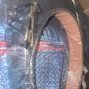 Svart bälte med silverfärgat spänne - Säljer ett svart bälte  med klassiskt rutigt mönster och ett stort silverfärgat. Bältet har en slät insida i beige skinn och är perfekt för att lyfta din outfit.