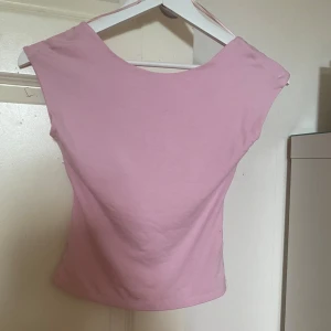 Ljusrosa topp från Gina Tricot - Säljer en ljusrosa topp från Gina Tricot. Toppen är ärmlös med en öppen rygg och har en tight passform. Perfekt för dig som vill ha en enkel men snygg topp till sommaren.