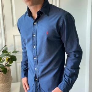 Ralph Lauren mörkblå skjorta långärmad - Nice Ralph Lauren skjorta mörkblå, inga defekter. Modellen bär M slim fit och är 180,75 kg. Kom med frågor! 