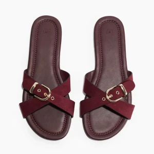 Vinröda sandaler med gulddetalj  - Snygga och populära vinröda sandaler från H&M med korsade remmar i mockaimitation och guldfärgade spännen. Slutsåld i alla storlekar. 