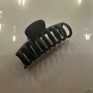 Svart hårklämma i enkel design - Stilren svart hårklämma med matt finish och klassisk form. Perfekt för att snabbt sätta upp håret med en clean look. Klämman har breda taggar som håller håret på plats hela dagen.