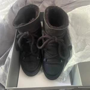 Inuikii boots - Säljer ett par svarta Inuikii boots med grov snörning och platt sula. Skorna har en rund tå och är fodrade med mjukt material på insidan för extra värme. Utsidan är i mocka och skinn, vilket ger en snygg och robust look. Perfekta för kalla dagar och riktigt stilrena. Storlek 36 är bara använda 1/2 gånger så inprencip nya, skriv om du har någon fråga, nypris 2999kr❤️