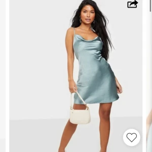 Ljusblå/grön satinklänning från Nelly - Supersnygg ljusblå/ljusgrön kort klänning i satin från Nelly med tunna axelband, urringning och öppen rygg med knyt. Perfekt om man t.ex. vill ha en kort bal/festklänning. Endast använd två gånger så mycket bra skick! Nypris 499kr