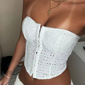 Vit broderad bandeu korsett - Superfin vit korsett från H&M med broderade spetsdetaljer. I väldigt bra skick🤍