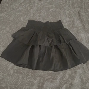 Svart och vit volangkjol med resår - Två söta korta kjolar i svart och vitt med bred smockresår i midjan och dubbla volanger. Kjolarna har en flowy look och passar perfekt till sneakers eller boots. Materialet känns lätt och luftigt, vilket gör dem sköna att bära under varmare dagar.