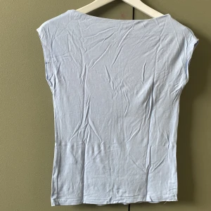 Ljusblå ärmlös tröja - En stilren ljusblå topp med ärmlös design och rund hals. Toppen är i mjukt material och har en enkel, clean look som passar perfekt till jeans eller kjol. Snyggt figurnära passform och lätt att matcha med andra plagg. Har en liten sminkfläck som lätt kan tvättas av. Använd 1 gång. Köptes för 80kr. pris kan förhandlas.