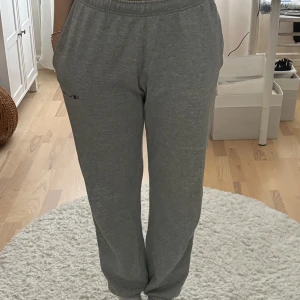 Grå mjukisbyxor från Champion  - Grå mjukisbyxor från Champion i storlek medium. Byxorna har resår i midjan och benslut , raka ben och sidofickor. Champion-logga broderad på ena benet. Tunt och mjukt material. 