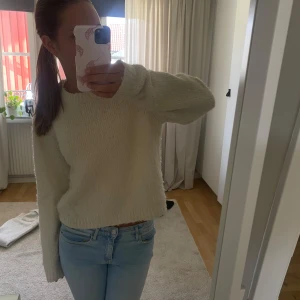 Beige stickaf tröja med lång ärm - Mysig beige stickad tröja med lång ärm och rund hals. Tröjan har en enkel och clean look, perfekt att slänga på sig när det är lite kyligt. Passformen är normal och materialet känns mjukt mot huden.