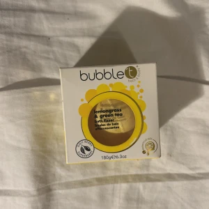 Badbomb Bubble T Lemongrass & Green Tea Bath Fizzer - En fräsch badbomb från Bubble T med doft av citrongräs och grönt te. Kommer i en rund gul förpackning på 180g. Innehåller eteriska oljor och gojibärsextrakt för en lyxig badupplevelse.