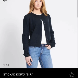 Mörkblå stickad kofta Siri - Mysig mörkblå stickad kofta från Siri med rund halsringning och knappar framtill. Koftan har lång ärm och en enkel, klassisk design som passar perfekt till jeans eller kjol. Skön och stilren för kyligare dagar.