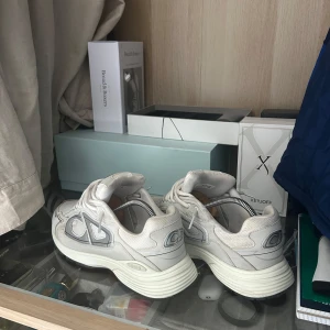 Christian Dior sneakers - Säljer mina b30 skor som är i bra skick men finns lite fläckar. Skorna är ljus beige och använda några gånger. Perfekta till sommaren och hösten. Hör av er vid frågor!