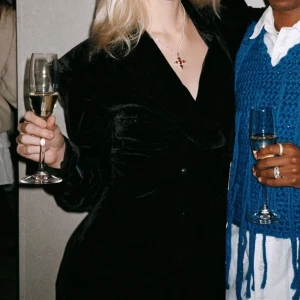 Svart kappa från H&M Edition - Elegant svart kappa från H&M Edition i ett mjukt och lyxigt material. Den har en klassisk design med långa ärmar och knappar framtill. Perfekt för att ge en stilren touch till din outfit.