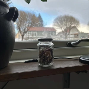 Mystery Jewerly Jar - En glasburk fylld med olika smycken, inklusive pärlor och kedjor i guld och silver. Perfekt för den som gillar att mixa och matcha sina accessoarer.