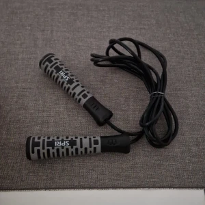 Hopprep med grå och svarta handtag - Säljer ett hopprep med ergonomiska handtag i grått och svart från SPRI. Perfekt för konditionsträning och smidigt att ta med sig. Repet är svart och handtagen har ett mönster för bättre grepp.