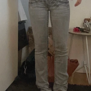 Grå jeans med bootcut - Snygga grå jeans med bootcut-stil och låg midjade. De har en klassisk femficksdesign och en diskret tvätt för en stilren look. Perfekta för en avslappnad men ändå trendig stil.