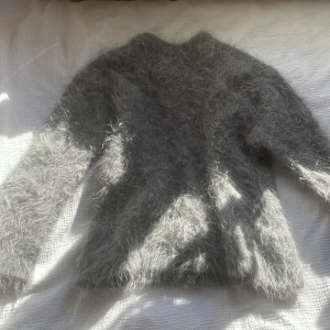 Grå fluffig tröja från Gina Tricot - Säljer en supermjuk och fluffig grå tröja från Gina Tricot. Perfekt för kyliga dagar med sin mysiga känsla. Tröjan har långa ärmar och en normal passform. Ett måste för garderoben! 💫